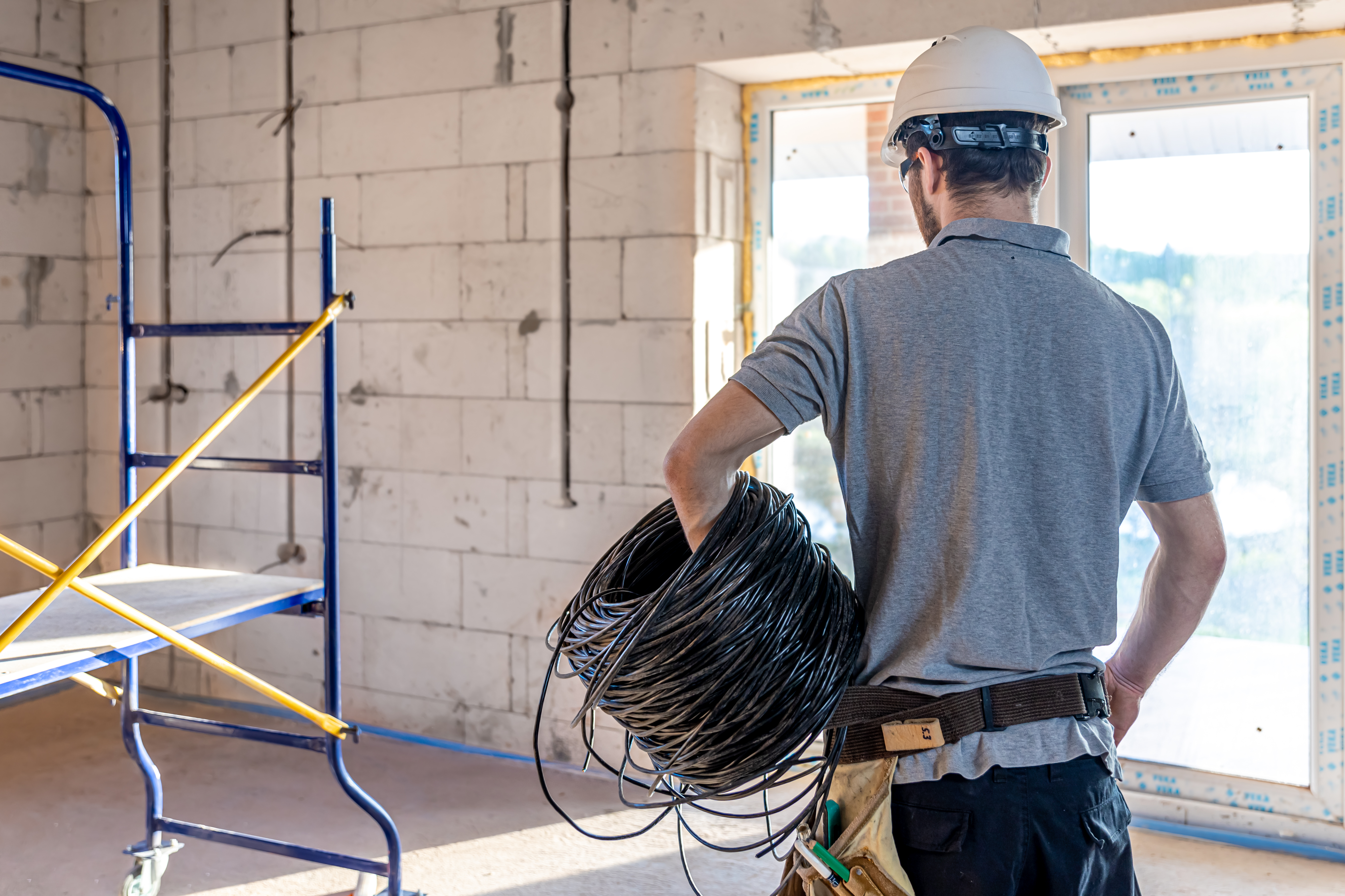 Qualities In The Electrician From American Lighting &Amp; Electrical Services In Palm Beach Gardens 1 An Electrician Contractor Examines A Blueprint At A Construction Site.